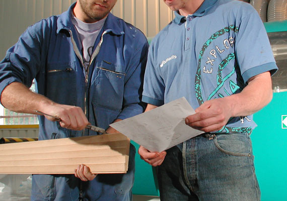 Deux personnes en train de travailler sur un projet de profil bois mouluré